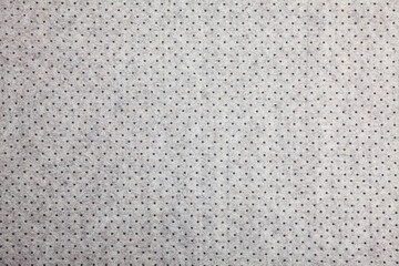 Background of light grey felt material with dark dots