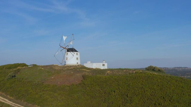 Aerial view The ancient windmills, Portugal. This is typical windmills, located in the on the hills in Portugal.
Circular tower mill has four trapezoidal sails made of wood. The four lattice framework