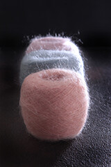 Multi-colored fluffy yarn on a black background. Yarn for hand knitting. Vertical photo. Black...