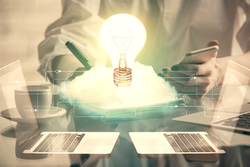 Double exposure of light bulb hologram and woman holding and using a mobile device. Idea concept.