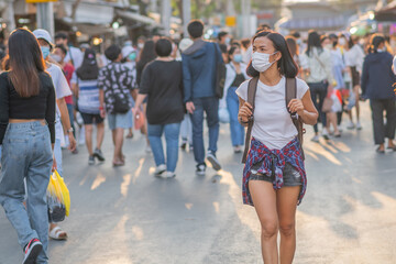 Tourists girls wearing face masks ar street. Happy travel of woman in sunny city centre. Women travel during coronavirus quarantine. Summer vacation. Chatuchak Weekend Market in Bangkok, Thailand
