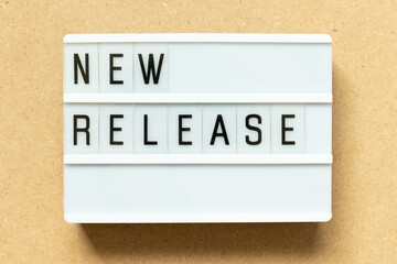 Lightbox with word new release on wood background