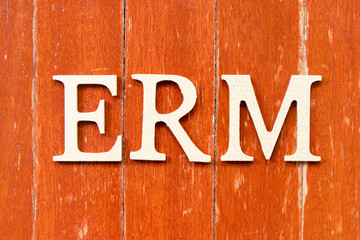Alphabet letter in word ERM (Abbreviation of Enterprise risk management) on old red color wood plate background