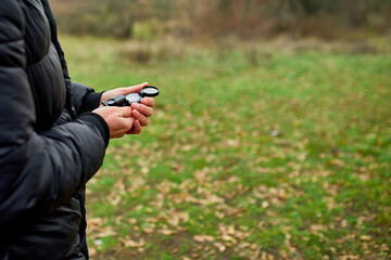 Traveler man with backpack with compass in hand on a background of mountains of nature