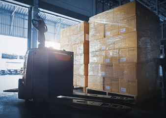 Stacked of Package Boxes with Electric Forklift Pallet Jack at The Storage Warehouse. Shipping...