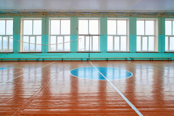 A school sports hall that has not been repaired for many years with an old wooden floor