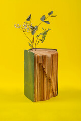 Vintage book with embedded flower branches on a yellow background