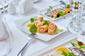 Beautifully decorated catering banquet table with different food snacks and appetizers , fresh fruits on corporate party event or wedding celebration