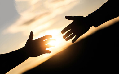 Fototapeta na wymiar Friendly handshake, friends greeting, teamwork, friendship. The outstretched hands, salvation, help silhouette, concept of help. Giving a helping hand. Rescue, helping gesture or hands