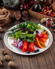 Fresh vegetables platter with greens on decorated background
