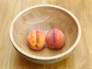 Two peach in wooden bowl. Concept, couple relations in common union