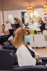 Woman getting hair dried in hair salon