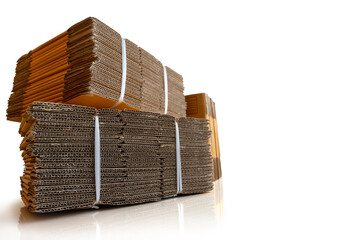 stack of corrugated cardboard boxes tied with nylon rope isolated on  white background and reflect on the floor.