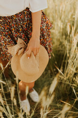 The spirit of travel, freedom and independence. Happy young couple in love running in the field in the sunset light. Messy hair. Freedom and love concept. Close up of holding hands. 