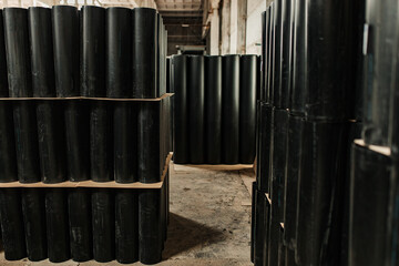 warehouse of black plastic and metal pipes. a plant for the production of pipelines. products...