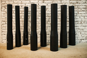 black cylindrical plastic pipes of different diameters are in stock. exhibition samples of the...