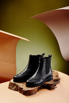 Black leather chelsea boots made of genuine leather in classic style on a wooden cut. Close-up. High quality photo