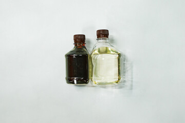 two plastic bottles with oil and combustible fuel. laboratory analysis of liquid samples. filled bottles on a white background. comparison of two liquid bubbles for chemical analysis