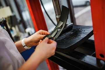 a worker with an industrial press. hold the workpiece in your hands for the part to work under high pressure. automated production machine operator