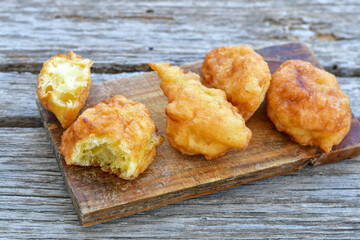 Traditional Bulgarian home made deep fried  patties  covered with sugar  оn rustic backgroud.Mekitsa or Mekica,  on wooden  rustic  background. Made of kneaded dough that is deep fried 