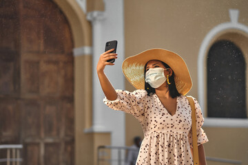 mujer en el centro de sincelejo con  sombrero  y cubreboca haciendo una selfie mirando hacia arriba y iglesia en la parte de atras