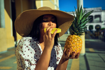 mujer con sombrero comiendo una piña en el centro de sincelejo