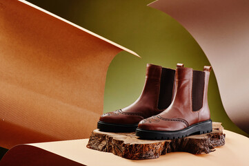 Brown leather chelsea boots made of genuine leather in classic style on a wooden cut. Close-up....