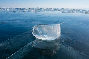 transparent ice floes lie on the transparent ice of the lake