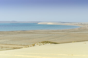 Scenic beauty of a desert where sand dunes descend into the sea