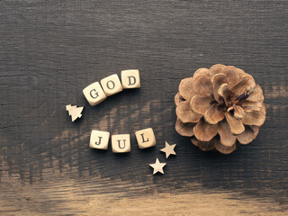 Pine cone and wooden dices with the words God Jul, Scandinavian Christmas card