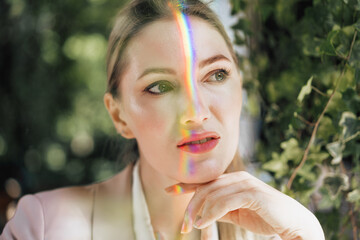Portrait of an attractive woman with rainbow light across face