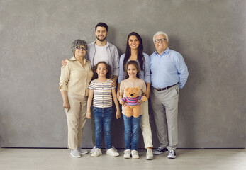 Studio photoshoot group portrait of happy big extended multi generational family. Cheerful mom,...