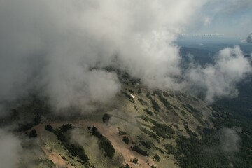 Obraz premium a volcano in clouds and white steam in the early morning. epic and mystical view of the mountain with thick fog around the old volcano