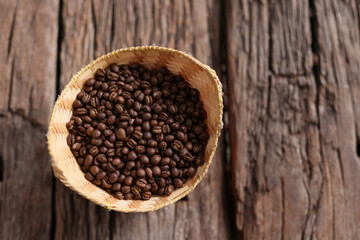 Coffee Beans Peaberry small size picking in bamboo basket. log wooden background. Selective focus on foreground with copy space.