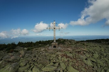 an old building on the top of a mountain in the summer at a ski resort. a sign for the conquerors of the top of tourist mountaineering