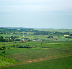 Fototapeta na wymiar A cell tower near a village in a field