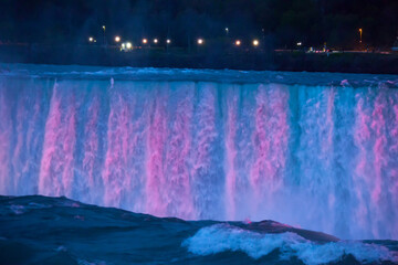 Niagara Falls at night under colored lights