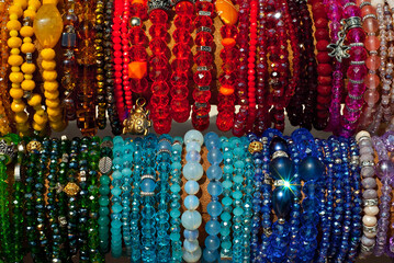 Necklace of colorful stones on the table. Many different jewelry and beads made of natural precious minerals. Beaded jewelry is on sale at the fair.