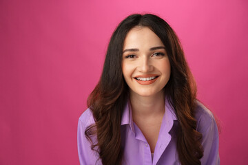 Young happy woman smiling over pink background