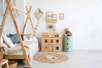 Stylish baby room with toys, wooden bed and mock up poster frame. Cute home decor. Scandinavian...