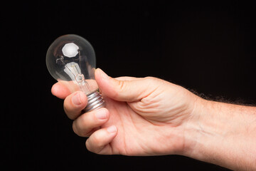 Light bulb in hand on a black background