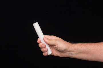 White candle on black background