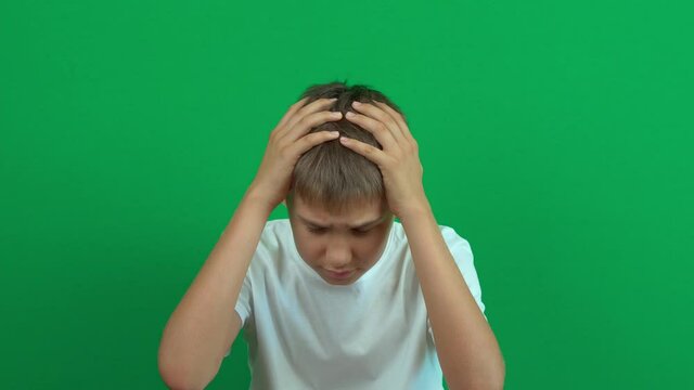 Sad disappointed teenage boy shaking his head in disbelief. Something bad has happened. Green screen chroma key background. 4k video