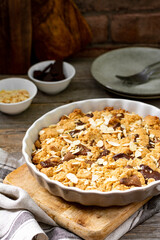 Homemade shortbread pie with milk and bitter chocolate in a baking dish on a gray wooden culinary background close-up. Delicious rustic sweet pastries