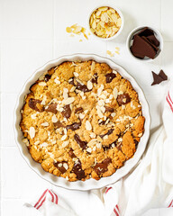 Homemade shortbread pie with milk and bitter chocolate in a baking dish on a white culinary background top view from a copy space. Delicious rustic sweet pastries