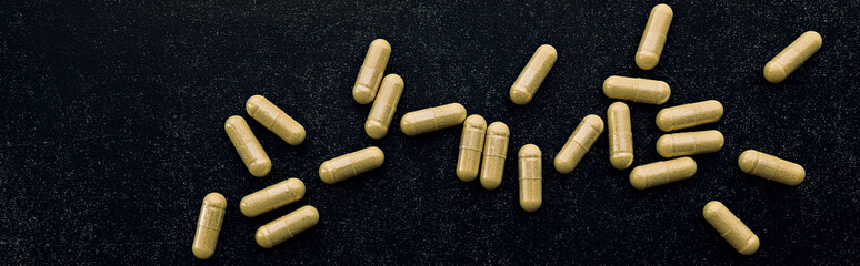 quercetin capsules on black background. dietary supplement top view banner. mental wellbeing and personal health concept