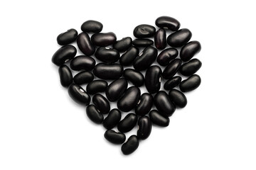 Heart shape made with black caribbean beans isolated on white background