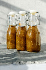 Bottles of chili hot sauce made from fermented chilies. Homemade Sriracha spicy sauce in bottles.
