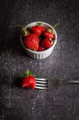 Strawberries are ripe, juicy, bright on a dark concrete background close-up from above