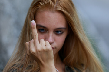 Rude vindictive young woman giving the middle finger